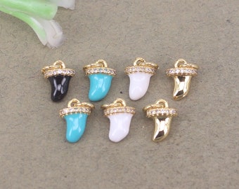 Puede incluir: Seis abalorios de tono dorado con forma de aleta de tiburón con una fila de piedras de cristal transparentes alrededor de la parte superior. Los abalorios son de diferentes colores: negro, turquesa, blanco y dorado.