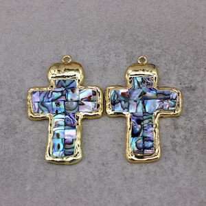 May include: Two gold-toned cross pendants with a mosaic of iridescent abalone shell inlay.