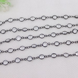 May include: A black chain with clear faceted beads. The chain is made of metal and is approximately 18 inches long.
