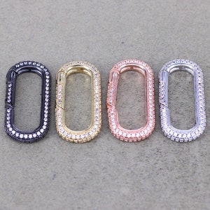 May include: Four oval-shaped clasps with a shiny metal finish and a row of clear rhinestones around the edge. The clasps are in black, gold, rose gold, and silver.