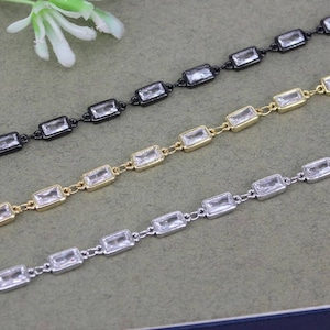 May include: Three chains with rectangular clear crystal accents. The chains are silver, gold, and black.