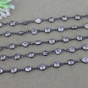 May include: A black chain with clear round beads. The chain is made of metal and is approximately 18 inches long.