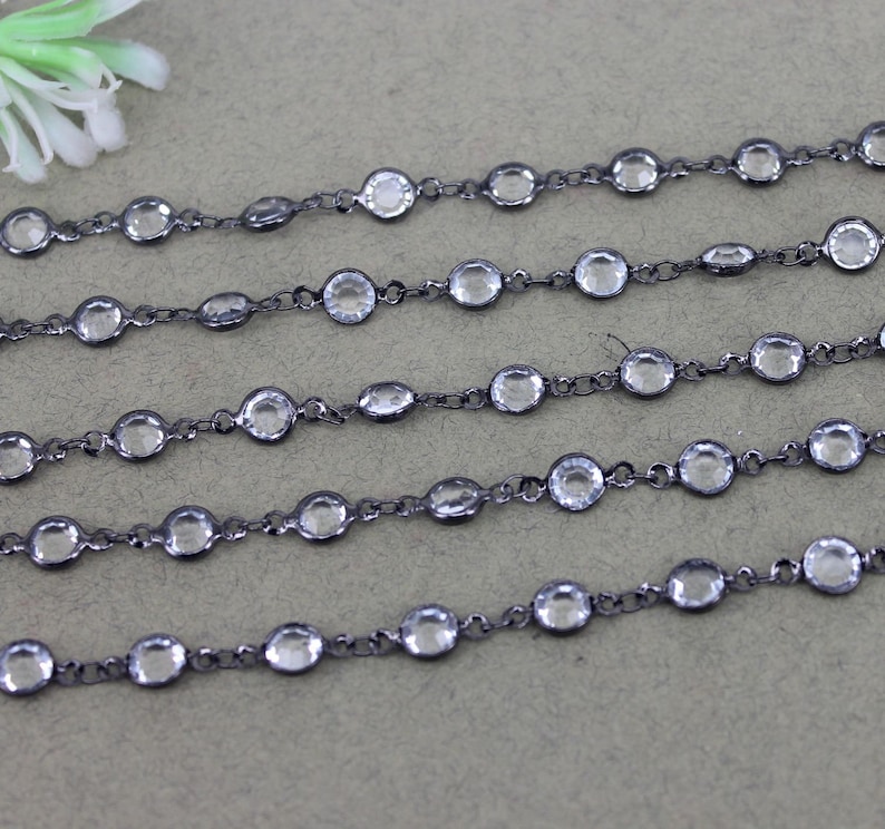 May include: A black chain with clear round beads. The chain is made of metal and is approximately 18 inches long.