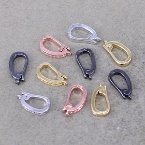 May include: Assortment of ten metal clasps in various finishes, including silver, gold, black, and rose gold. Each clasp features a decorative design and a secure closure.