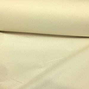 May include: A close-up of a roll of off-white fabric with a slightly textured surface.