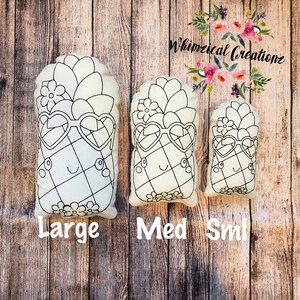 May include: Three white canvas pineapple pillows in different sizes, labeled "Large", "Med", and "Sml". Each pillow features a black outline of a pineapple with sunglasses and a flower on top.