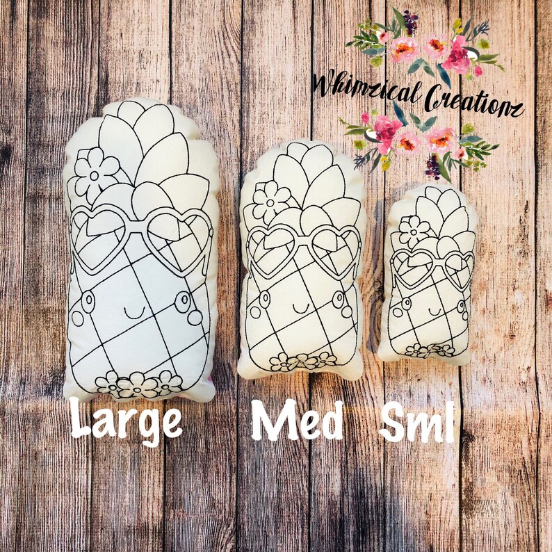 May include: Three white canvas pineapple pillows in different sizes, labeled "Large", "Med", and "Sml". Each pillow features a black outline of a pineapple with sunglasses and a flower on top.