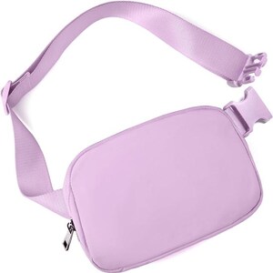 May include: A light purple fanny pack with an adjustable strap and a plastic buckle closure. The bag has a rectangular shape with a zipper closure and a matching strap. The fanny pack is designed to be worn around the waist or across the body.