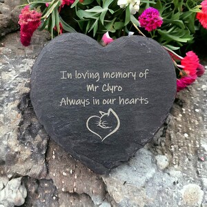 May include: A black heart-shaped slate stone with the inscription "In loving memory of Mr. Clyro Always in our hearts" and a small engraved image of a cat inside a heart.