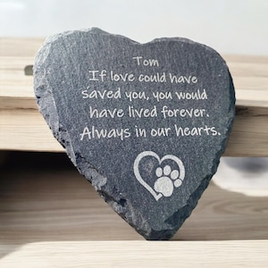 May include: A gray heart-shaped slate stone with the inscription "Tom If love could have saved you, you would have lived forever. Always in our hearts." and a paw print inside a heart.