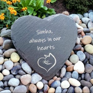 May include: A gray heart-shaped slate stone memorial with the inscription "Simba, always in our hearts" and a stylized cat sleeping in a heart.