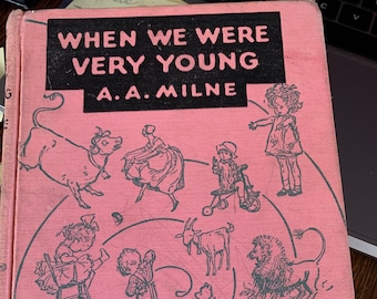 May include: A pink book cover with the title "When We Were Very Young" by A.A. Milne. The cover features illustrations of children and animals in a whimsical, swirling pattern.