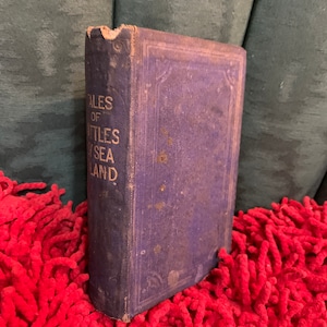 May include: A vintage, blue, hardcover book with the title "Tales of the Little Sea Island" on the spine.