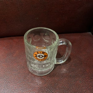 May include: A clear glass mug with a raised design and a handle. The mug has a red and yellow logo that says "A&W Root Beer".