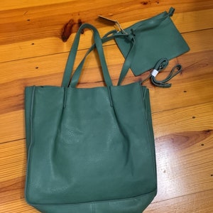 Puede incluir: Un conjunto de bolso tote y bandolera a juego de color verde. El bolso tote tiene asas largas y un compartimento principal grande. El bolso bandolera tiene una correa para el hombro. Ambos bolsos est&aacute;n hechos de un material texturizado.