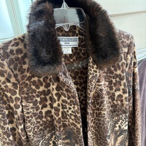 May include: A brown and tan leopard print jacket with a faux fur collar. The jacket has a button closure and is labeled "Jessica Howard Petite".