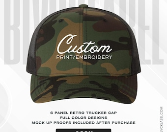 Può includere: Un cappellino trucker a sei pannelli con motivo mimetico nei toni del verde, marrone e nero. Il pannello frontale mostra la scritta bianca Custom PRINT/EMBROIDERY. Il cappellino include una rete nera sul retro e una visiera curva coordinata.