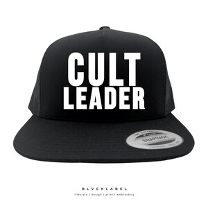 May include: Black trucker hat with a white mesh back. The front of the hat has the text "CULT LEADER" in white.