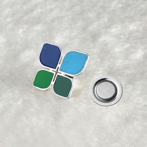 May include: A silver magnetic pin with a four-leaf clover design. The clover is made of four different colored enamel pieces: blue, green, teal, and dark green.