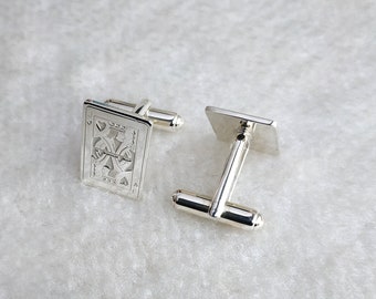 以下が含まれることがあります： 銀製のカフスボタン2つ。1つはハートのジャックのカードが細かく彫刻されている。