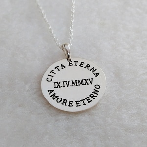 May include: Silver necklace with a round pendant that reads "Citta Eterna IX.IV.MMXV Amore Eterno".