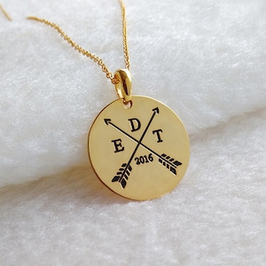 May include: Gold necklace with a round pendant featuring the letters "EDT" and the year "2016" with crossed arrows.
