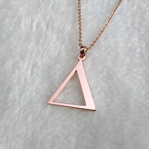 Peut inclure: Un collier en or rose avec un pendentif en forme de triangle simple.