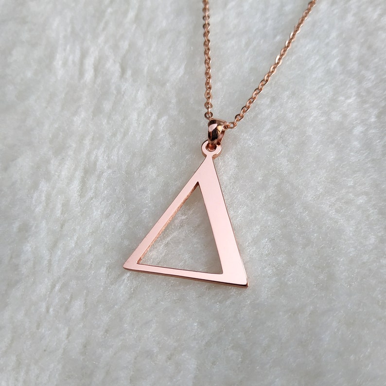 Peut inclure: Un collier en or rose avec un pendentif en forme de triangle simple.