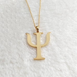Peut inclure: Un collier en or avec un pendentif en forme de lettre grecque psi.