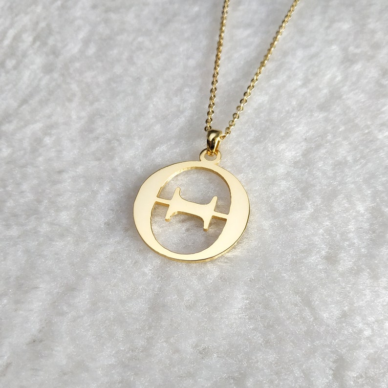 Peut inclure: Un collier en or avec un pendentif en forme de lettre 'O' avec un 'H' plus petit &agrave; l'int&eacute;rieur. Le pendentif est sur une d&eacute;licate cha&icirc;ne en or.