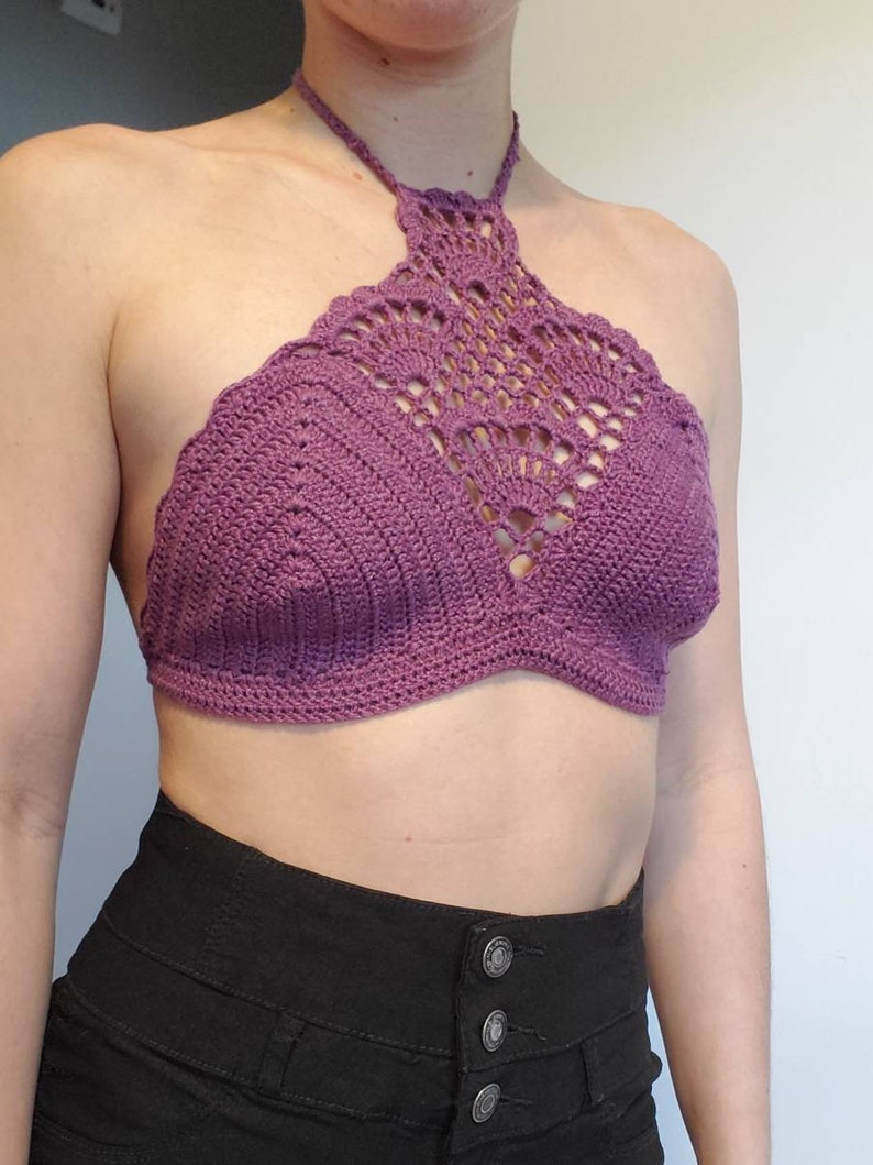 Pu&ograve; includere: Un top halter color porpora lavorato a uncinetto con un motivo delicato. Il top &egrave; corto e ha uno stile a halter.