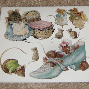 May include: A set of vintage stickers featuring illustrations of mice in various scenes. The stickers include a mouse family in a crib, a mouse in a blue shoe, and a group of mice playing. The stickers are printed on white paper with a light brown background.