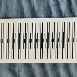 May include: White plastic sound diffuser with a pattern of vertical lines of varying lengths. The diffuser has the text "TSW" printed on the bottom right corner.
