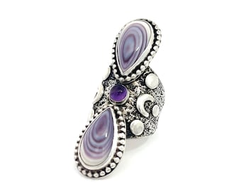 May include: A silver-toned statement ring featuring two large, teardrop-shaped stones with a swirling, lavender and white pattern. The ring also has a small, round purple stone and decorative silver accents, including moons and dots.