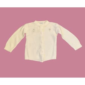 May include: Cream-colored cardigan sweater with long sleeves and a button-up front. The sweater features delicate floral embroidery near the neckline. A classic, soft knit garment for children.
