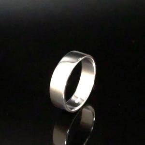 May include: A simple silver band ring with a smooth, polished finish.