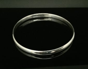 May include: A simple silver bangle bracelet with a smooth, polished finish.