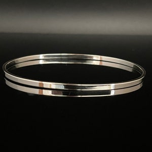 May include: A silver bangle bracelet with a polished finish.