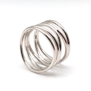 May include: Silver ring with five bands twisted together. The ring is a simple design with a polished finish.