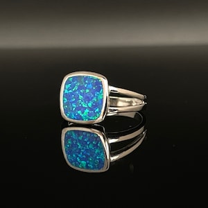 Könnte beinhalten: Ein silberner Ring mit einem quadratischen blauen Opal-Edelstein.