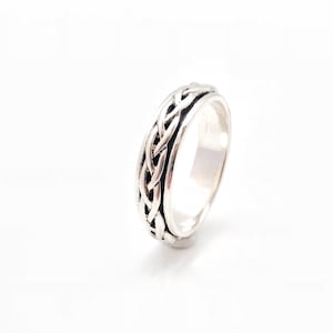May include: A silver ring with a braided design. The band is smooth and the braid is textured.