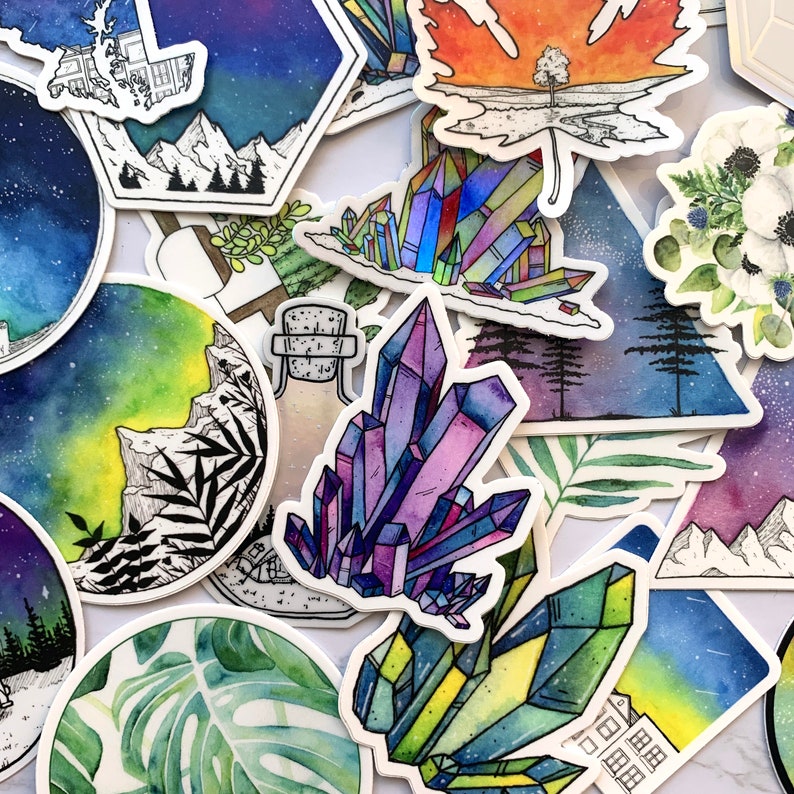 May include: A collection of colorful watercolor stickers featuring various designs, including crystals, a forest scene, a bottle, a leaf, and a mountain range. The stickers are perfect for adding a touch of whimsy to journals, laptops, water bottles, and more.