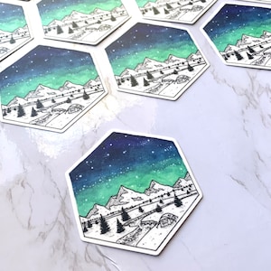 May include: A hexagonal sticker with a watercolor background of a starry night sky with a green aurora borealis. The sticker features a black line drawing of a mountain range with a tent in the foreground.