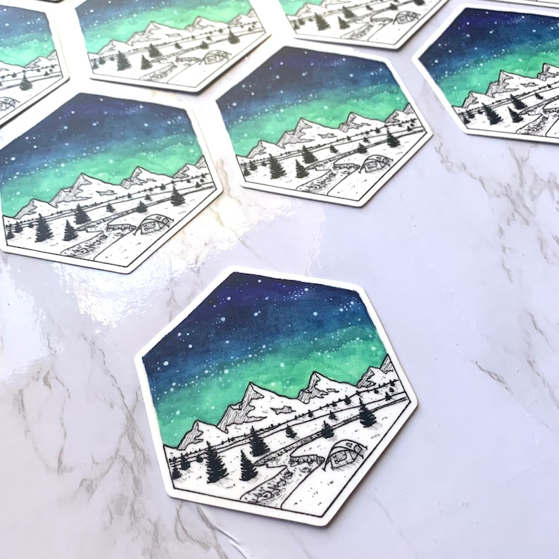 May include: A hexagonal sticker with a watercolor background of a starry night sky with a green aurora borealis. The sticker features a black line drawing of a mountain range with a tent in the foreground.