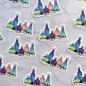 May include: A set of colorful glass bottles with galaxy-themed designs. Each bottle has a different color and pattern, and they are all arranged in a row. The bottles are perfect for adding a touch of whimsy to any home decor.