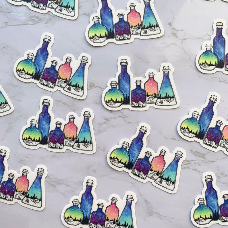 May include: A set of colorful glass bottles with galaxy-themed designs. Each bottle has a different color and pattern, and they are all arranged in a row. The bottles are perfect for adding a touch of whimsy to any home decor.