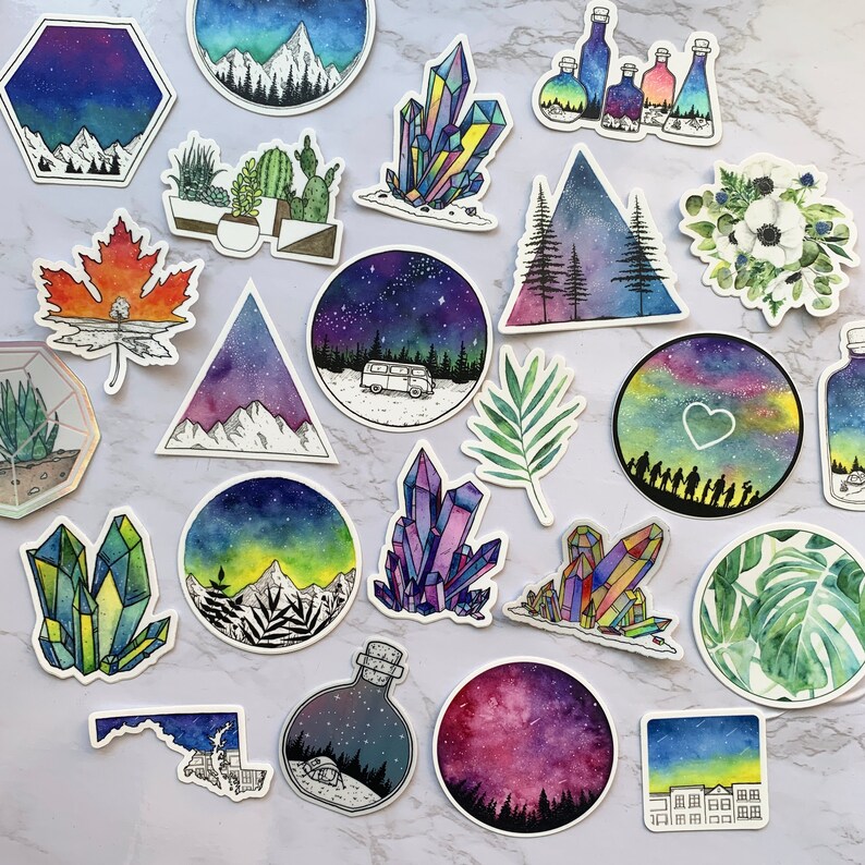 Puede incluir: Una colecci&oacute;n de pegatinas de acuarela con varios dise&ntilde;os. Las pegatinas incluyen im&aacute;genes de monta&ntilde;as, cristales, una furgoneta bajo un cielo estrellado, una hoja de arce y elementos bot&aacute;nicos. La paleta de colores incluye azules, morados, verdes y naranjas.
