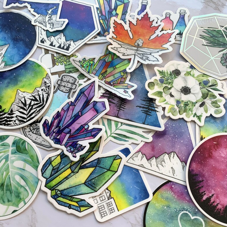 May include: A collection of colorful, hand-painted stickers featuring various designs, including crystals, flowers, mountains, and celestial scenes. The stickers are perfect for adding a touch of whimsy and personalization to laptops, water bottles, journals, and more.