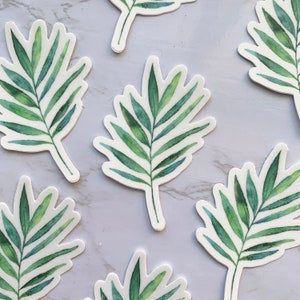 May include: Six white stickers with green watercolour palm leaves. The leaves are arranged in a random pattern.