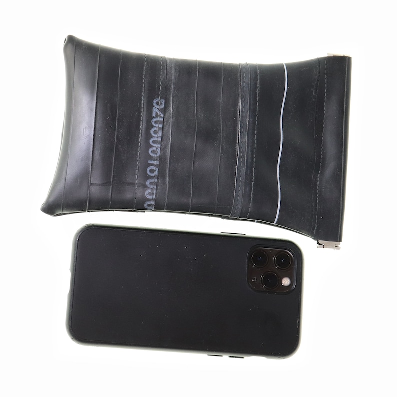 May include: A black smartphone with a triple lens camera system and a black recycled inner tube phone case.